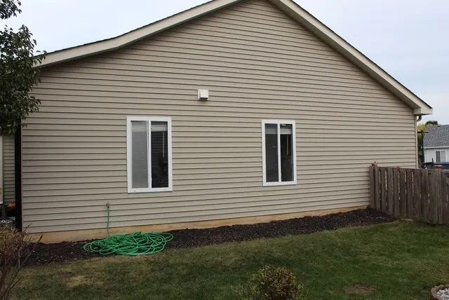 a view of a white house next to a yard
