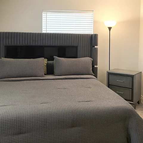 a bedroom with a bed and a night stand