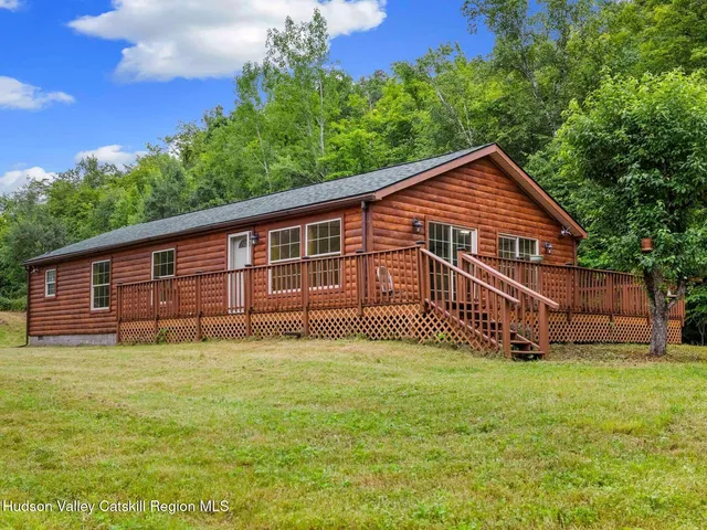 a view of a house with a yard and deck