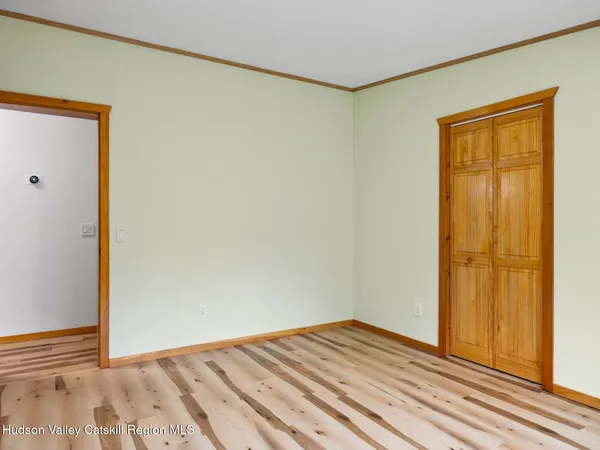 an empty room with wooden floor and closet area