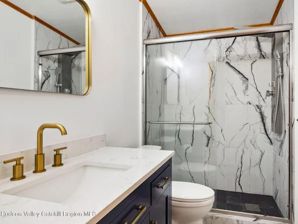 a bathroom with a granite countertop sink a toilet and shower curtain