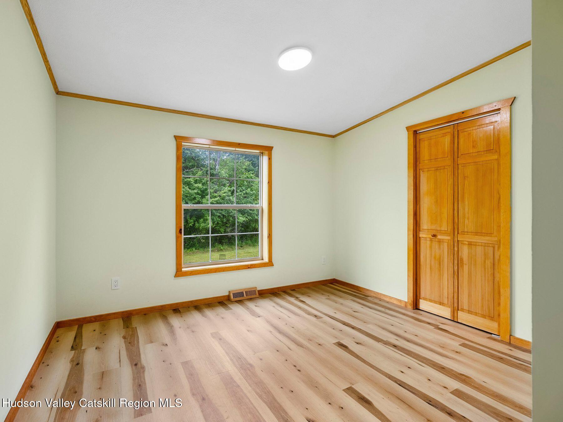 719 Allen Teator Road Durham, NY 12469 - Photo 24 of 38 a view of an empty room with wooden floor and a window