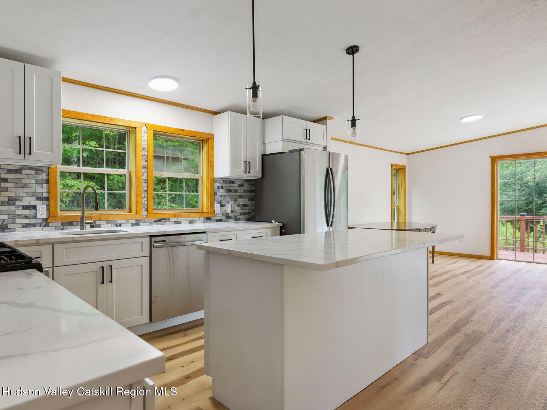 719 Allen Teator Road Durham, NY 12469 - Photo 4 of 38 a kitchen with stainless steel appliances granite countertop a refrigerator a sink dishwasher a oven and a dining table with wooden floor