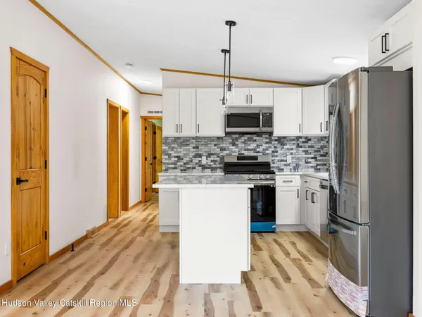a kitchen with stainless steel appliances a refrigerator sink and microwave