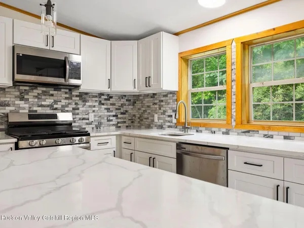 a kitchen with stainless steel appliances a stove sink microwave and cabinets