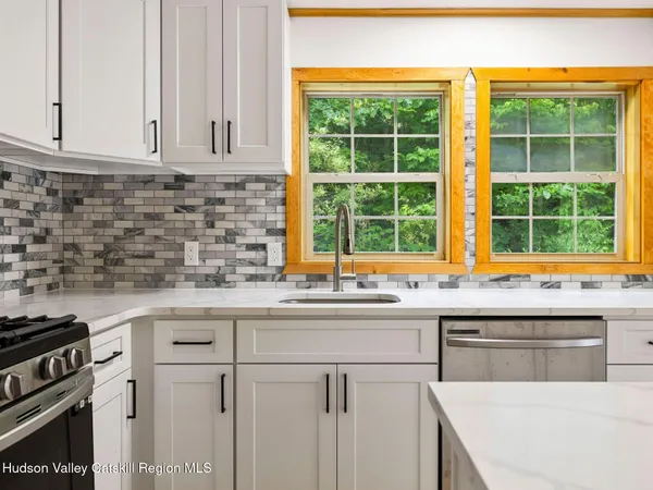a kitchen with stainless steel appliances granite countertop a sink and a stove
