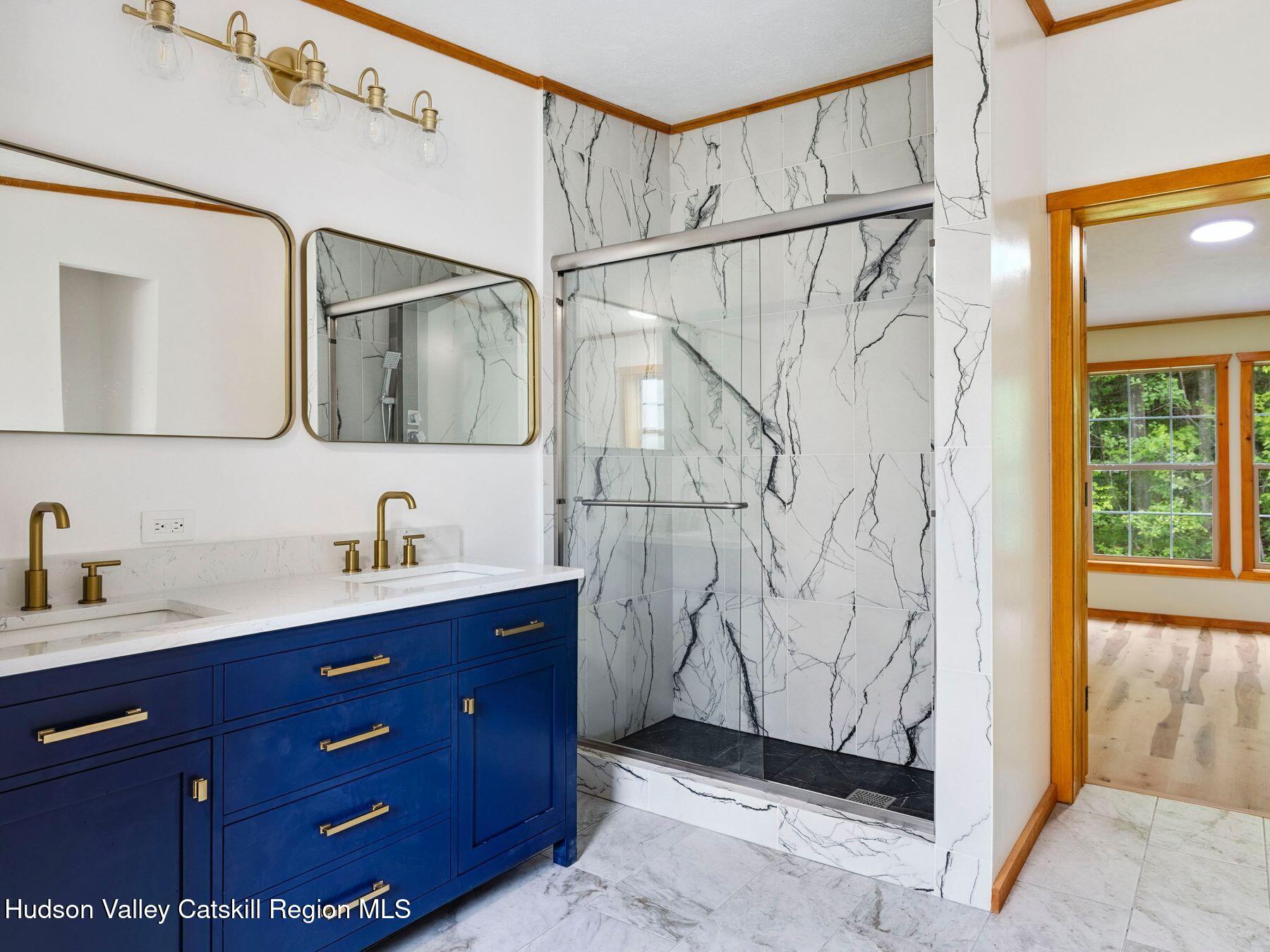 719 Allen Teator Road Durham, NY 12469 - Photo 10 of 38 a bathroom with a granite countertop sink a mirror a vanity and shower