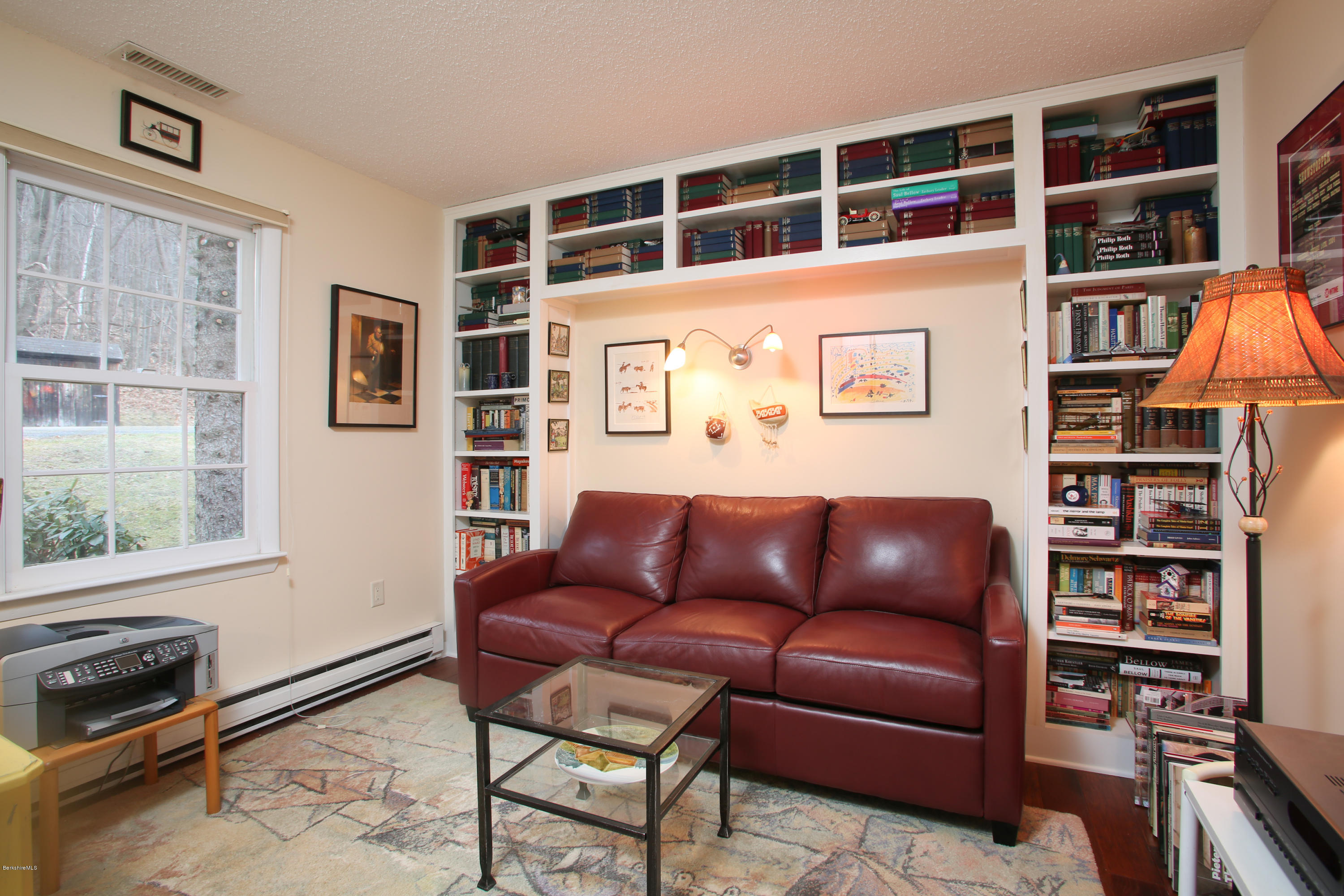 1041-104 Beaver Pond Road, Unit A Hancock, MA 01237 - Photo 6 of 13 a blue couch sitting in front of a book shelf