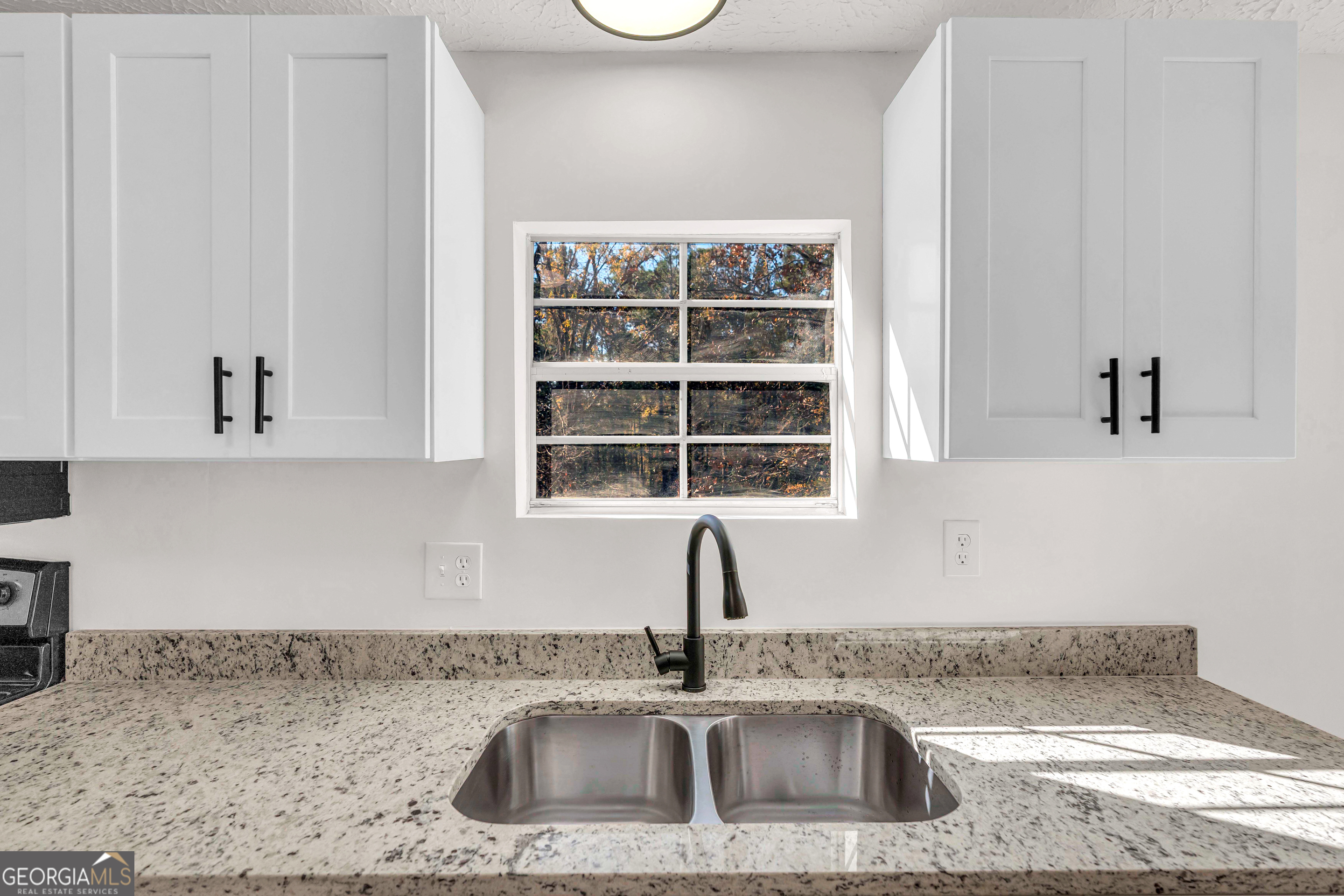 395 Barnetts Bridge Road Jackson, GA 30233 - Photo 29 of 82 a kitchen with a sink a window and cabinets