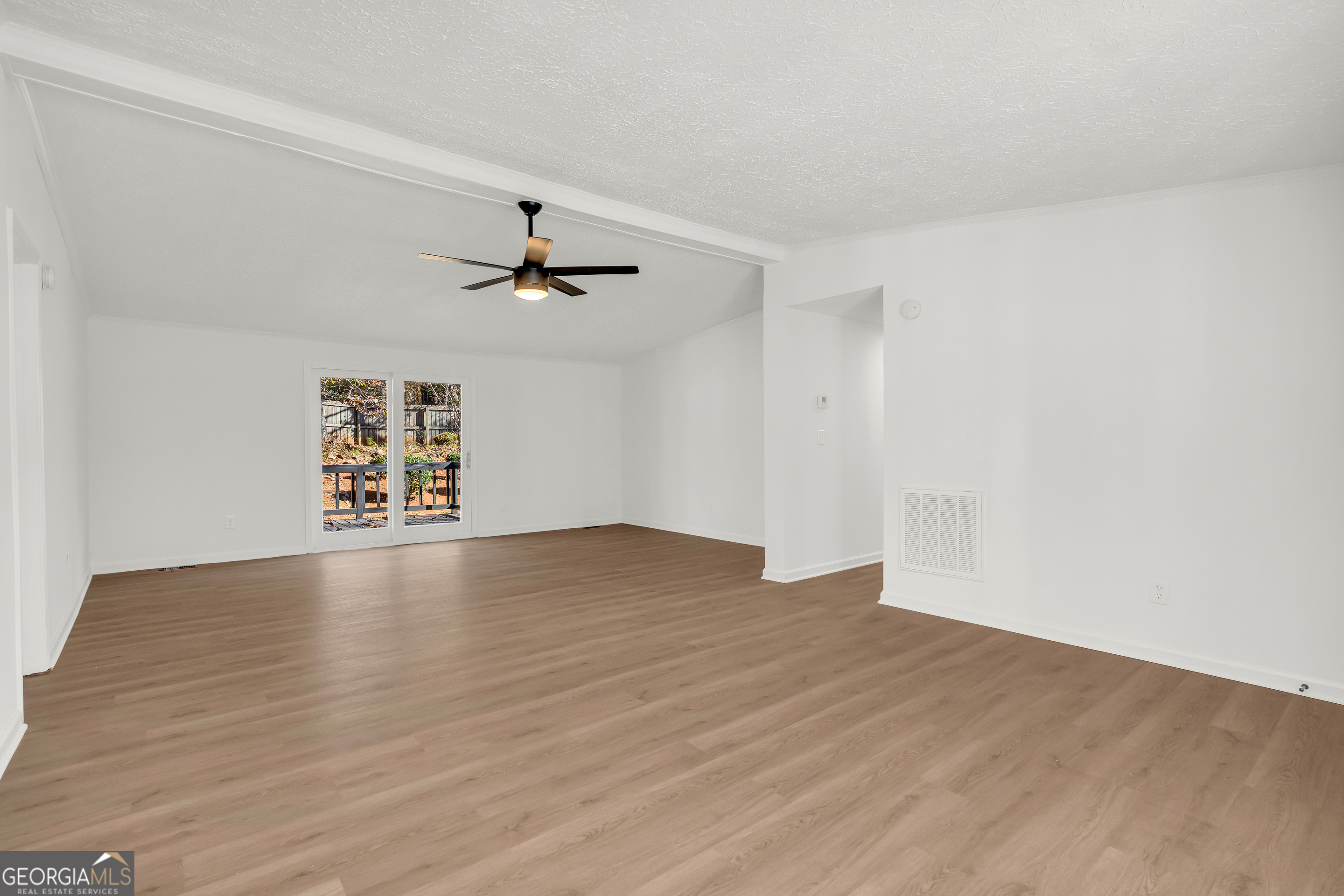 395 Barnetts Bridge Road Jackson, GA 30233 - Photo 5 of 82 a view of an empty room with wooden floor and a ceiling fan