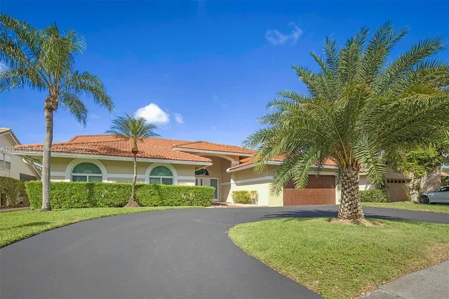 a front view of a house with a yard and potted plants