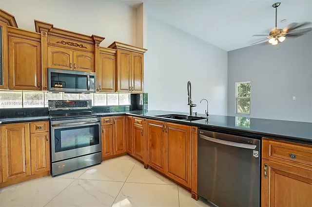 a kitchen with granite countertop cabinets stainless steel appliances and a sink