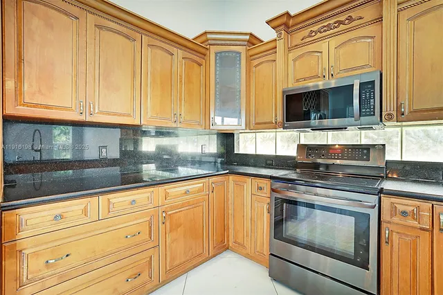 a kitchen with stainless steel appliances granite countertop a refrigerator and cabinets