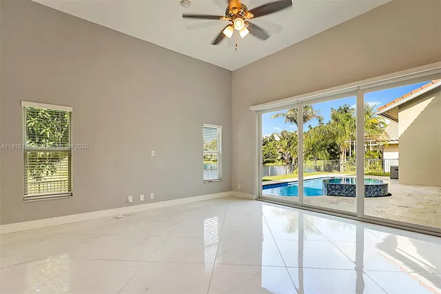 a view of a livingroom with a chandelier fan and windows