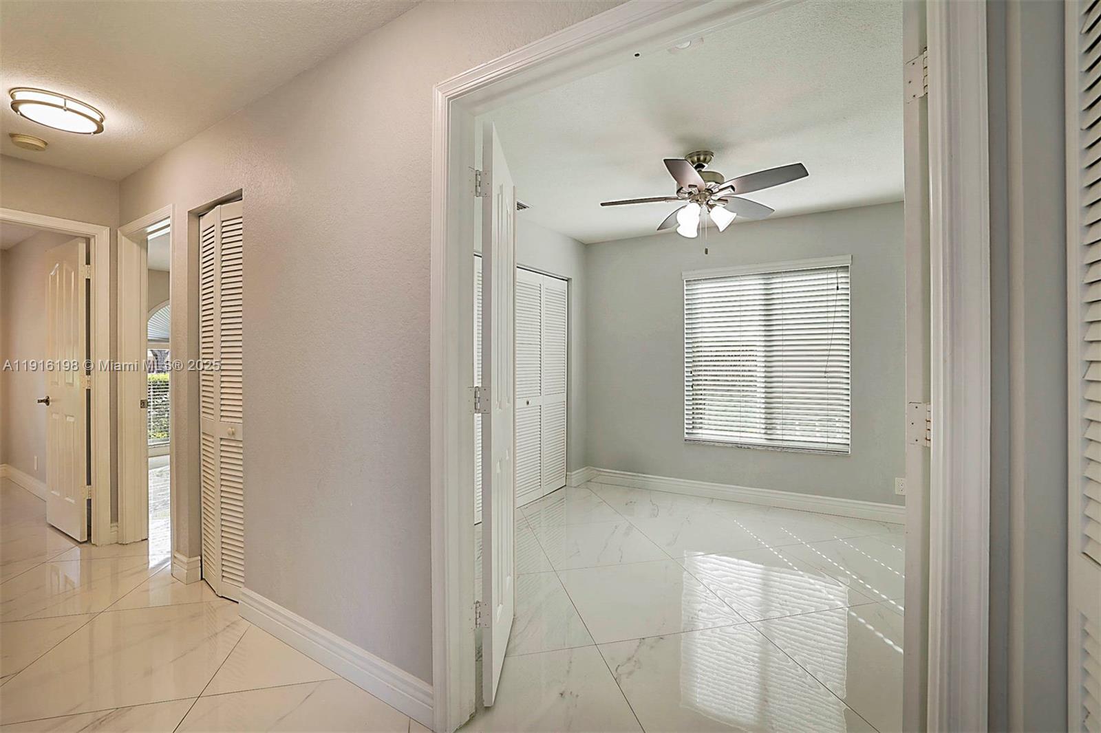 10133 Northwest 48th Drive Coral Springs, FL 33076 - Photo 30 of 49 a view of an empty room with a ceiling fan and a window