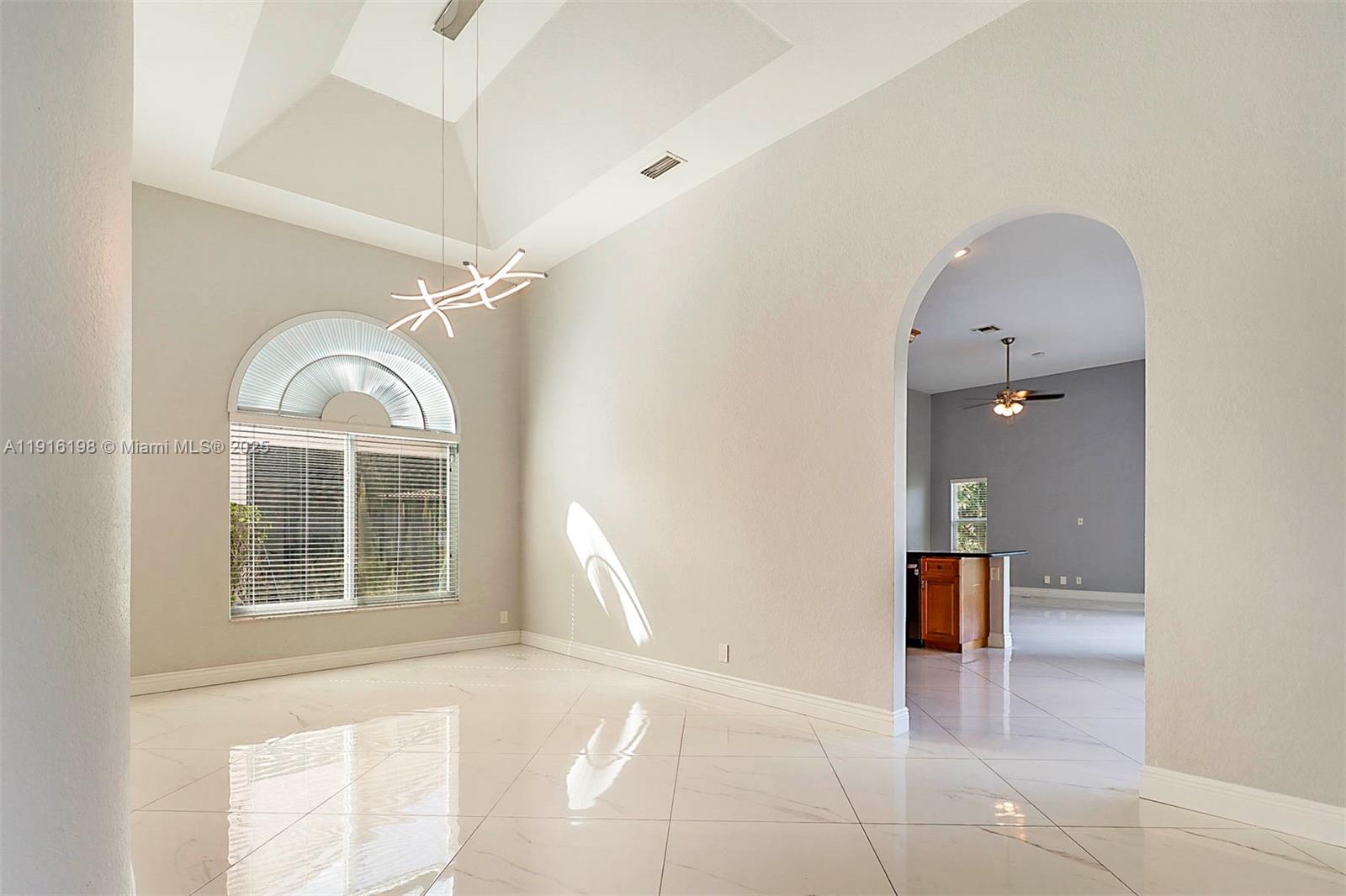 10133 Northwest 48th Drive Coral Springs, FL 33076 - Photo 9 of 49 a view of a room with a large window and chandelier