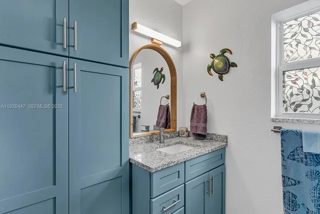 a bathroom with a granite countertop sink and a mirror