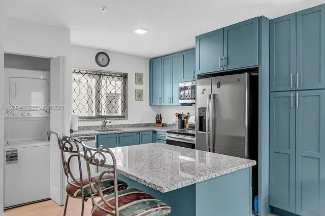a kitchen with stainless steel appliances granite countertop a refrigerator and a stove top oven