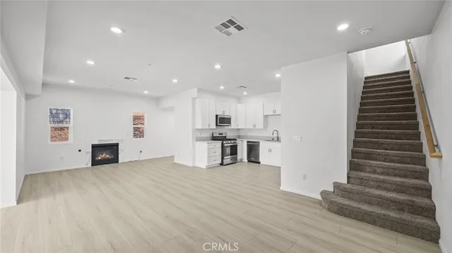 a view of a kitchen with stairs and an empty room