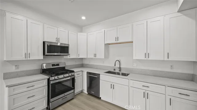 a kitchen with white cabinets and stainless steel appliances