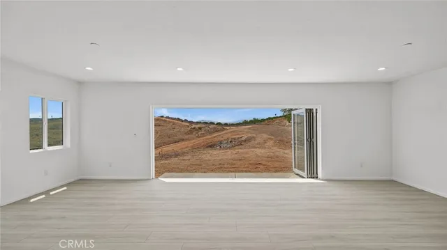 an empty room with wooden floor and a window