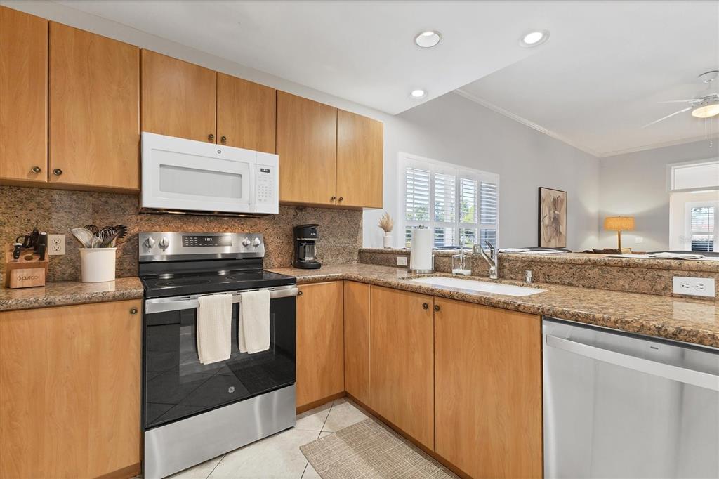3605 54th Drive West, Unit 104 Bradenton, FL 34210 - Photo 14 of 65 a kitchen with stainless steel appliances granite countertop a stove a sink and a refrigerator