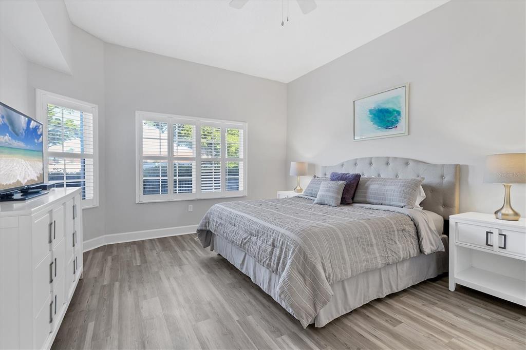 3605 54th Drive West, Unit 104 Bradenton, FL 34210 - Photo 18 of 65 a bedroom with a bed and a flat tv screen on dresser