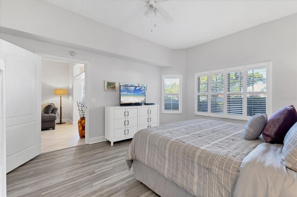 3605 54th Drive West, Unit 104 Bradenton, FL 34210 - Photo 19 of 65 a spacious bedroom with a bed a table and a large window