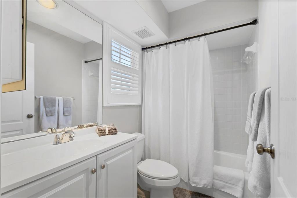 3605 54th Drive West, Unit 104 Bradenton, FL 34210 - Photo 24 of 65 a bathroom with a sink a mirror a toilet and shower