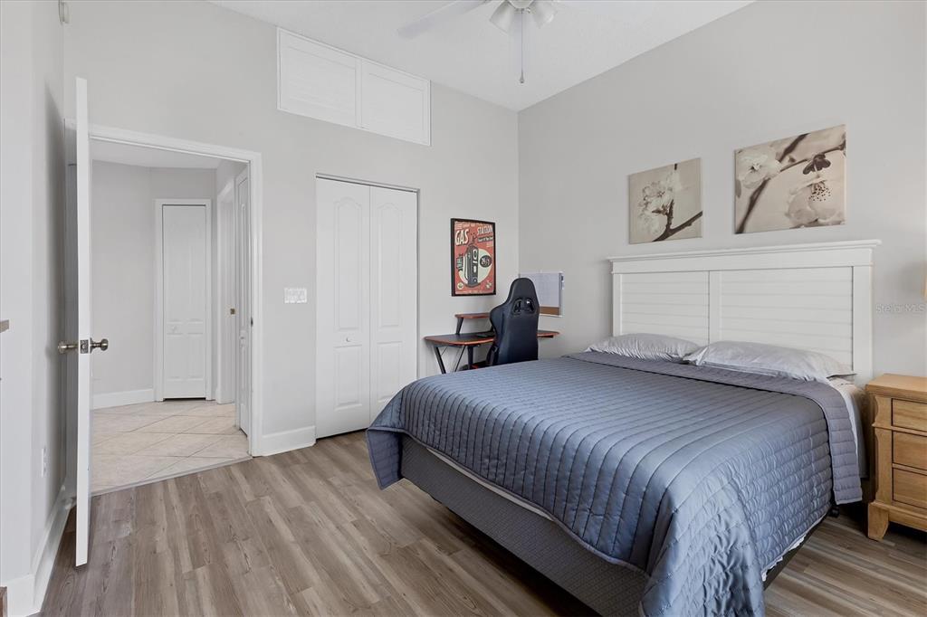 3605 54th Drive West, Unit 104 Bradenton, FL 34210 - Photo 26 of 65 a bedroom with a bed and a chandelier