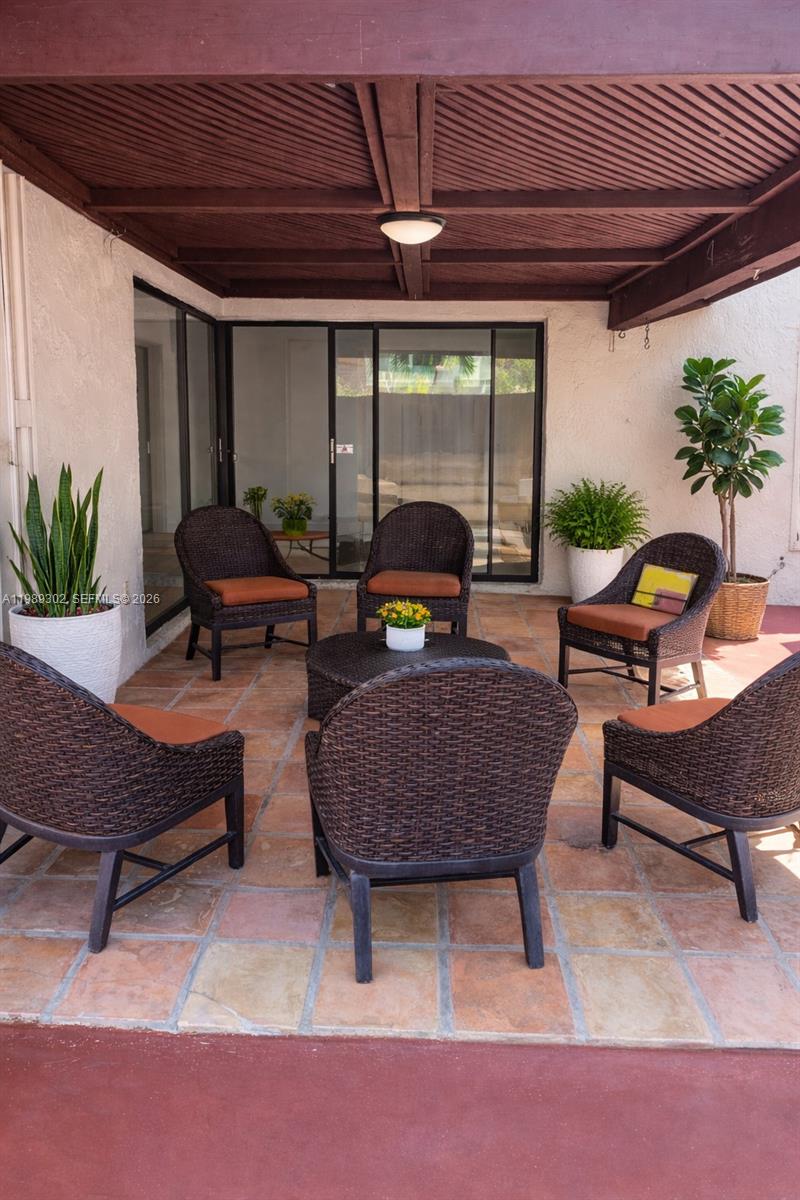 441 Northwest 98th Court, Unit 441 Miami, FL 33172 - Photo 16 of 18 a outdoor living space with furniture and a black umbrella