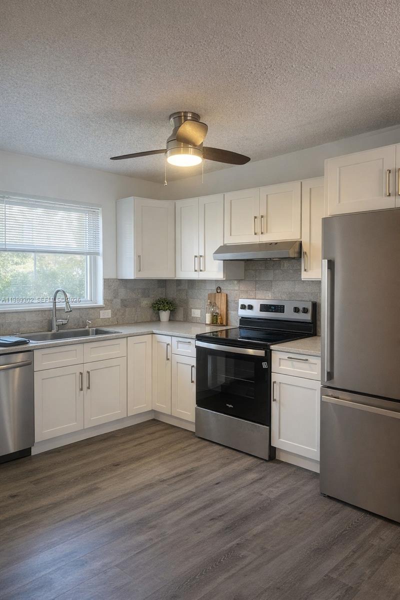 441 Northwest 98th Court, Unit 441 Miami, FL 33172 - Photo 2 of 18 a kitchen with granite countertop stainless steel appliances a refrigerator and a stove top oven