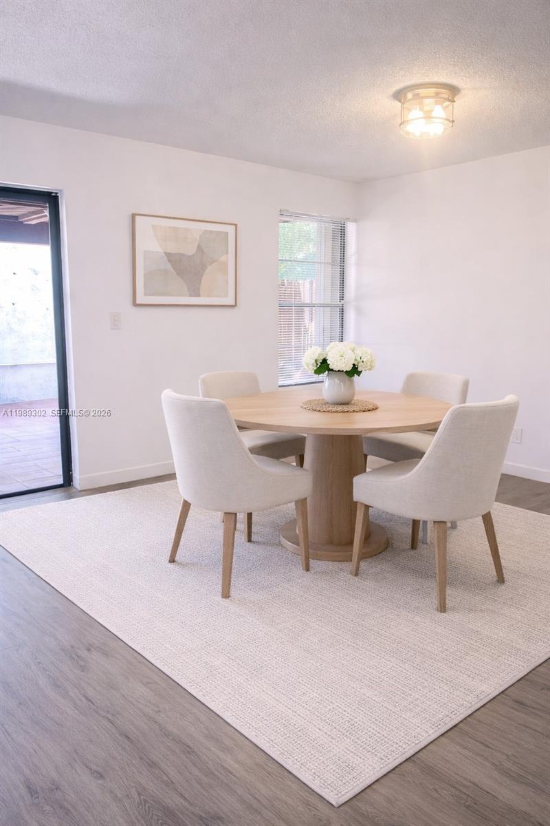 441 Northwest 98th Court, Unit 441 Miami, FL 33172 - Photo 3 of 18 a view of a dining room with furniture and wooden floor