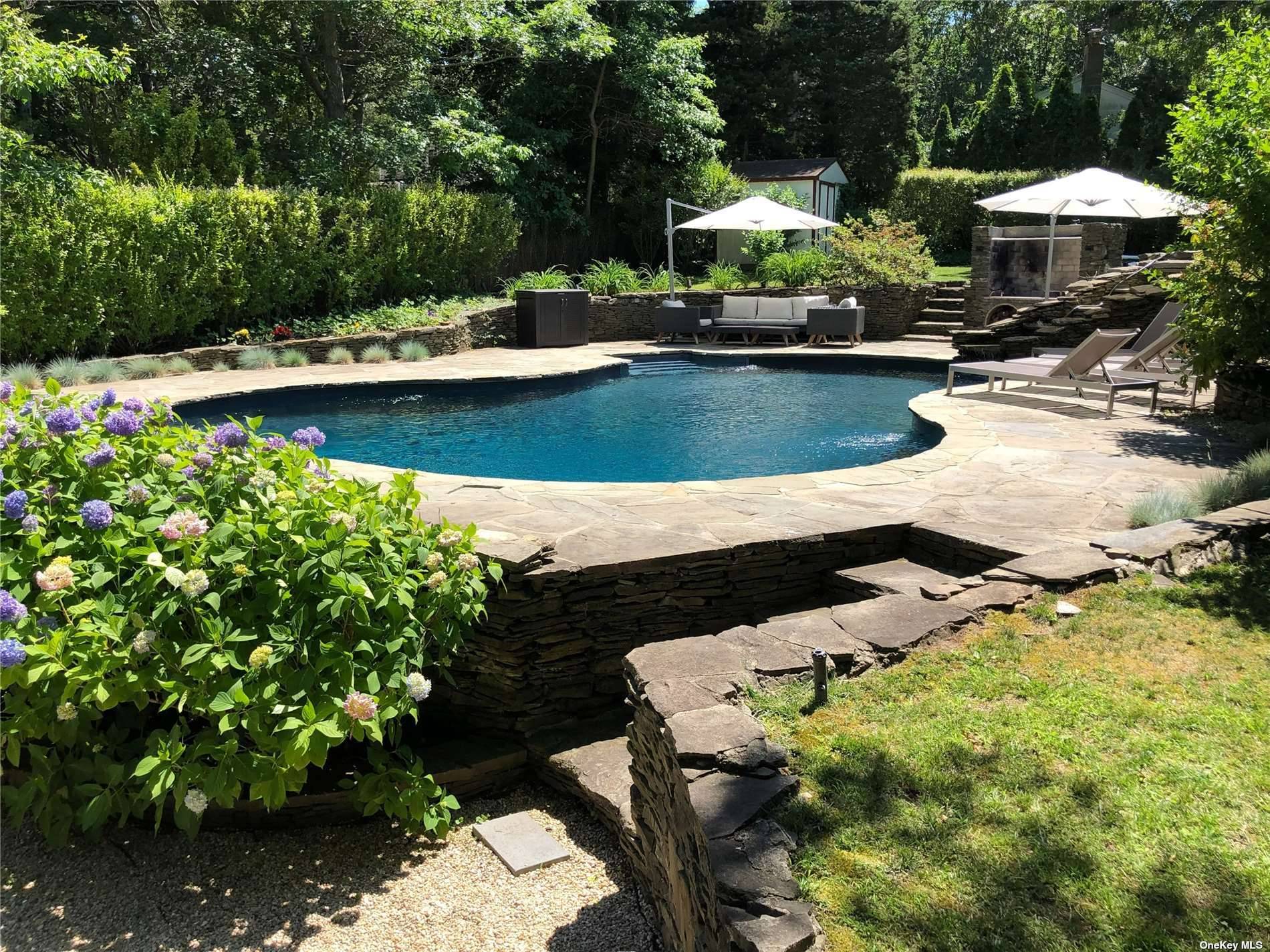 3752 Noyack Road Sag Harbor, NY 11963 - Photo 12 of 28 a view of swimming pool with lawn chairs under an umbrella