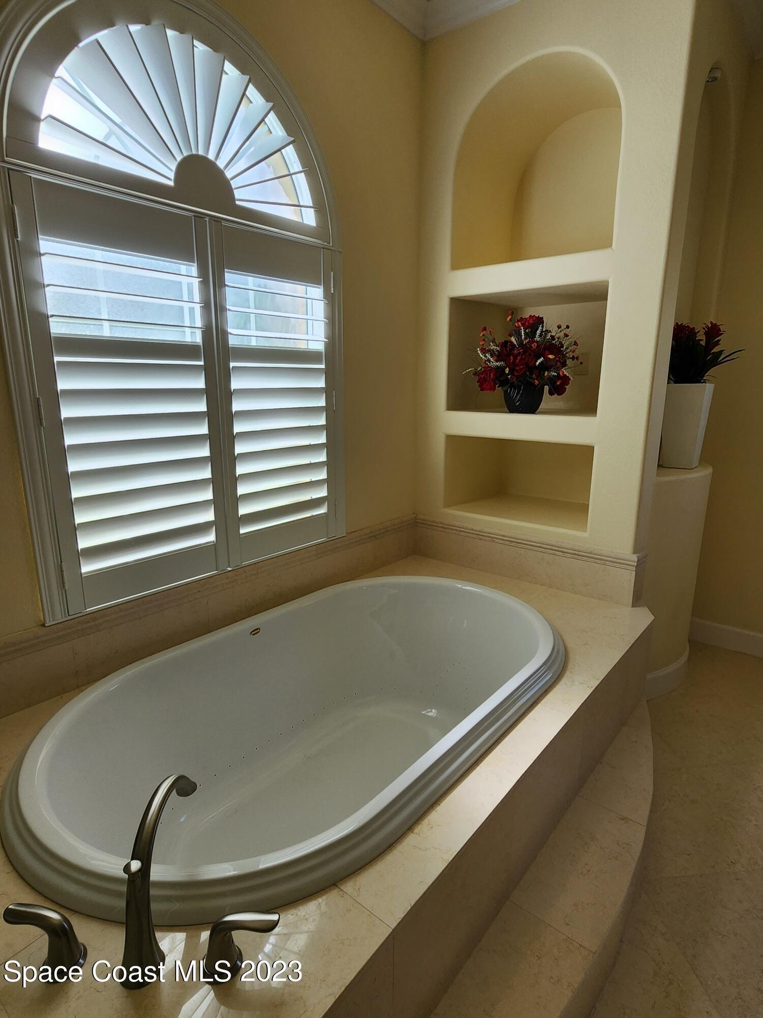 4124 Waterloo Place Melbourne, FL 32940 - Photo 16 of 32 a bathroom with a tub and a window