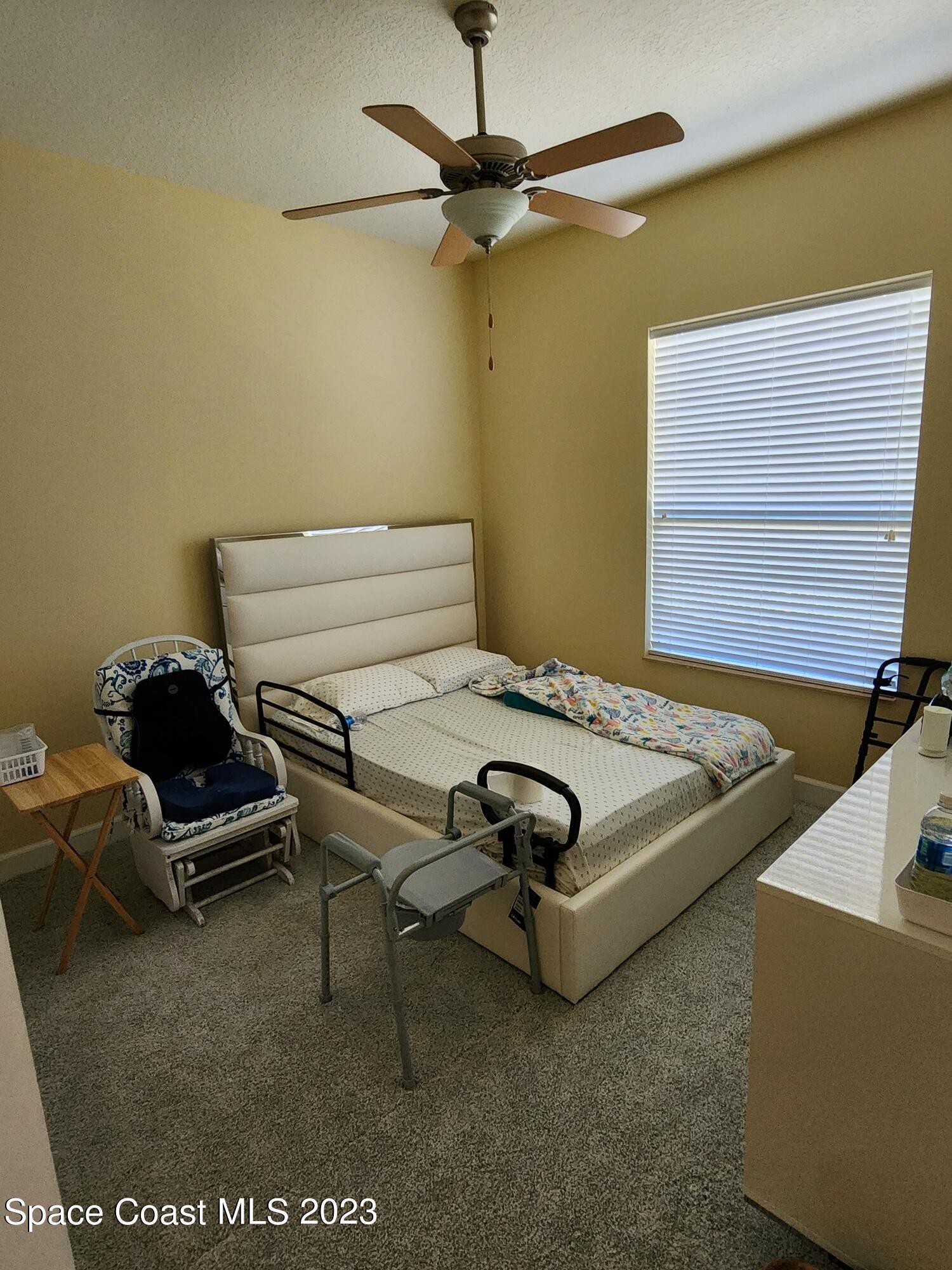 4124 Waterloo Place Melbourne, FL 32940 - Photo 17 of 32 a bedroom with a bed and a chandelier