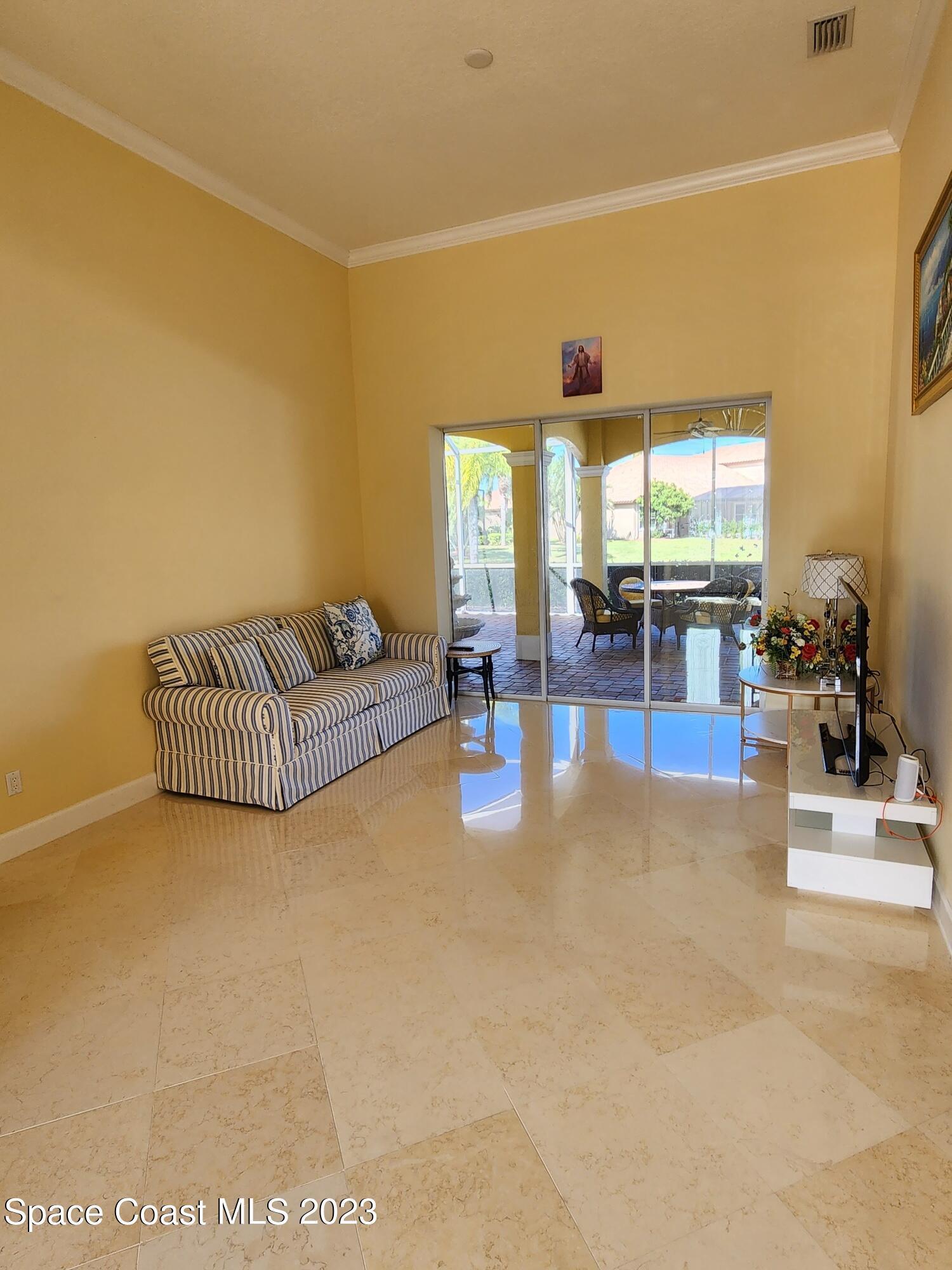 4124 Waterloo Place Melbourne, FL 32940 - Photo 5 of 32 a living room with furniture and a chandelier