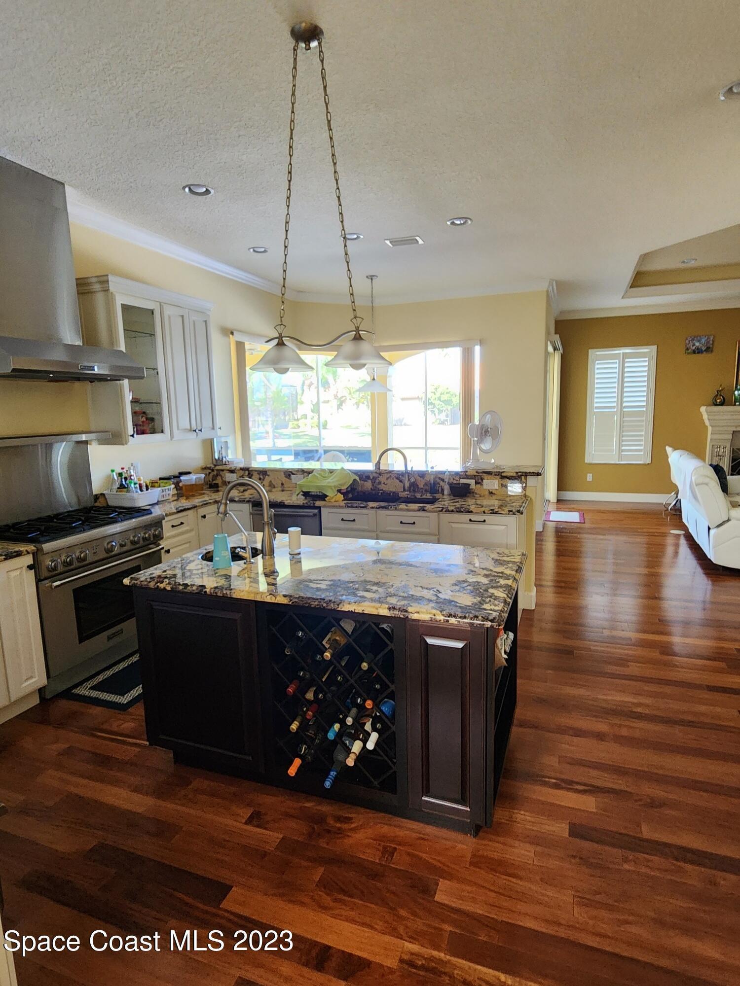4124 Waterloo Place Melbourne, FL 32940 - Photo 8 of 32 a kitchen with stainless steel appliances granite countertop a stove and a wooden floors