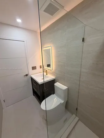 a bathroom with a sink a toilet and mirror