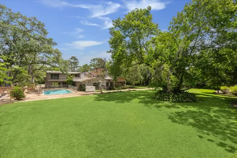 a view of yard with swimming pool and green space