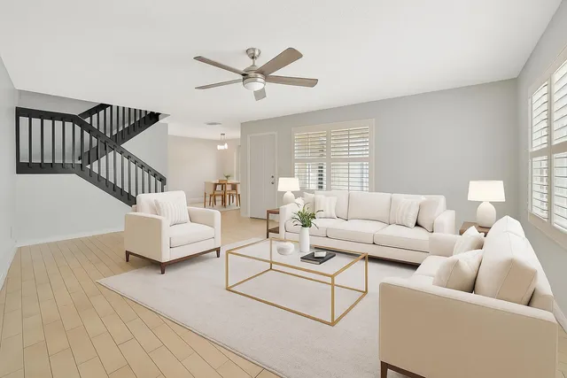 a living room with furniture and a wooden floor