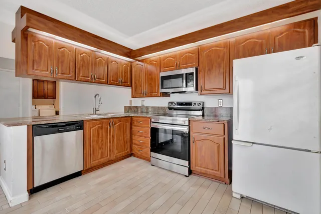 a kitchen with stainless steel appliances granite countertop a refrigerator sink and stove