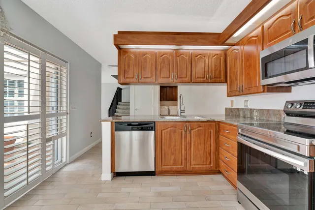 a kitchen with stainless steel appliances granite countertop a refrigerator and a stove top oven