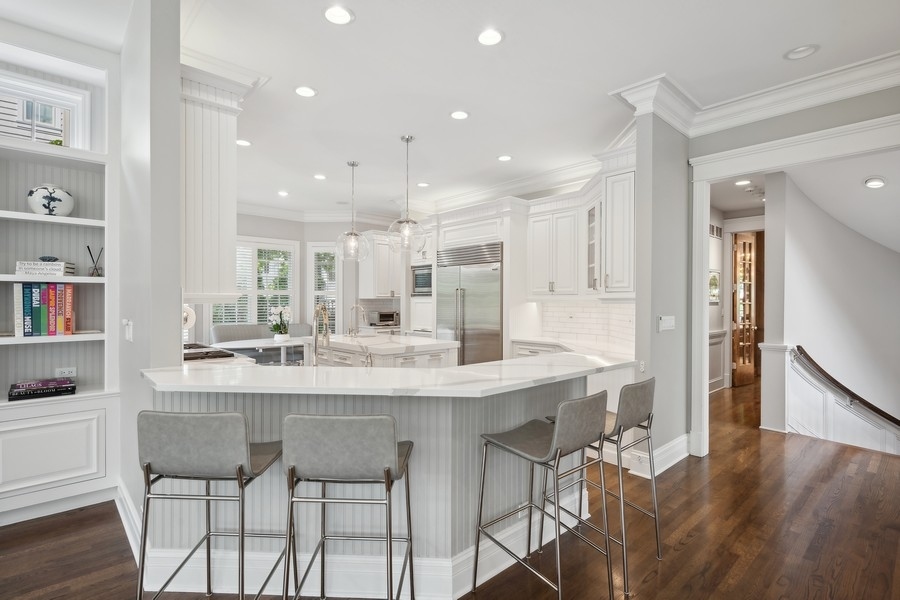 502 Willow Road Winnetka, IL 60093 - Photo 15 of 37 a kitchen with kitchen island a dining table chairs cabinets and wooden floor