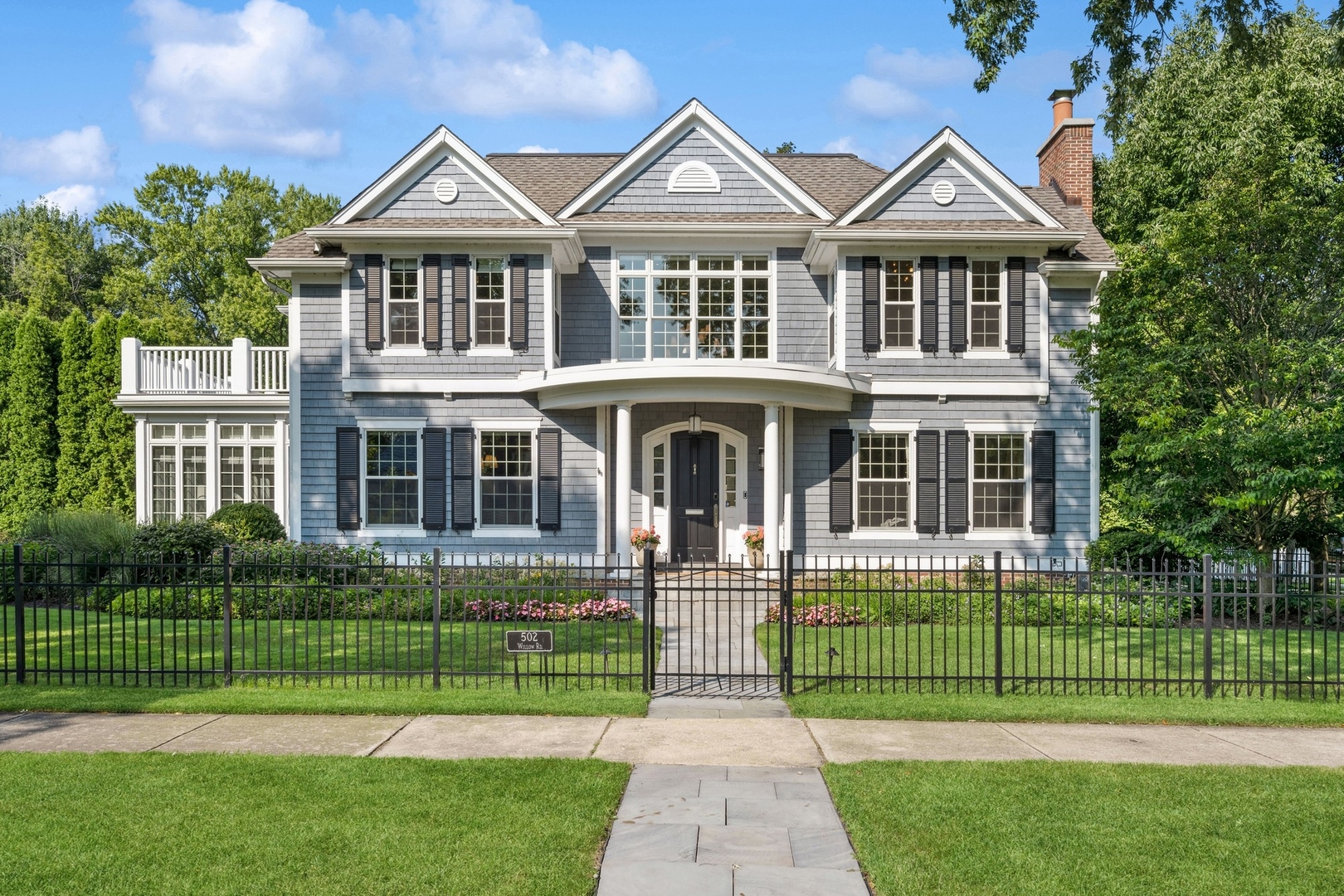 502 Willow Road Winnetka, IL 60093 - Photo 2 of 37 a front view of a house with a garden and trees