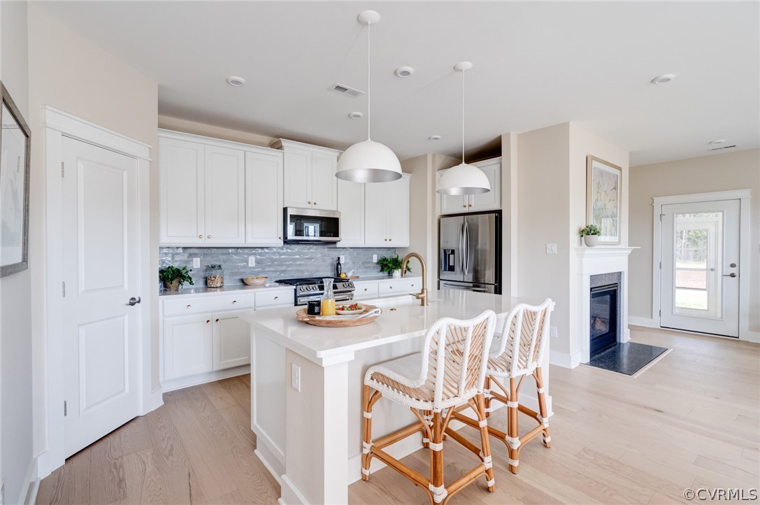 a kitchen with stainless steel appliances granite countertop a white cabinets and chairs