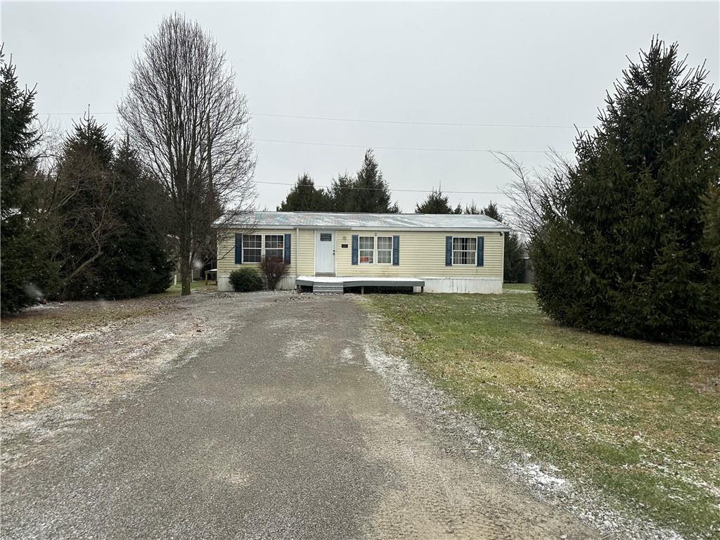 101 Haylees Lane Butler, PA 16002 - Photo 2 of 14 a view of a white house next to a yard with large trees