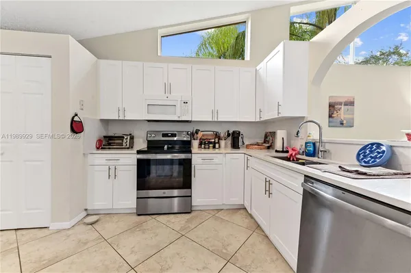 a kitchen with white cabinets and white appliances