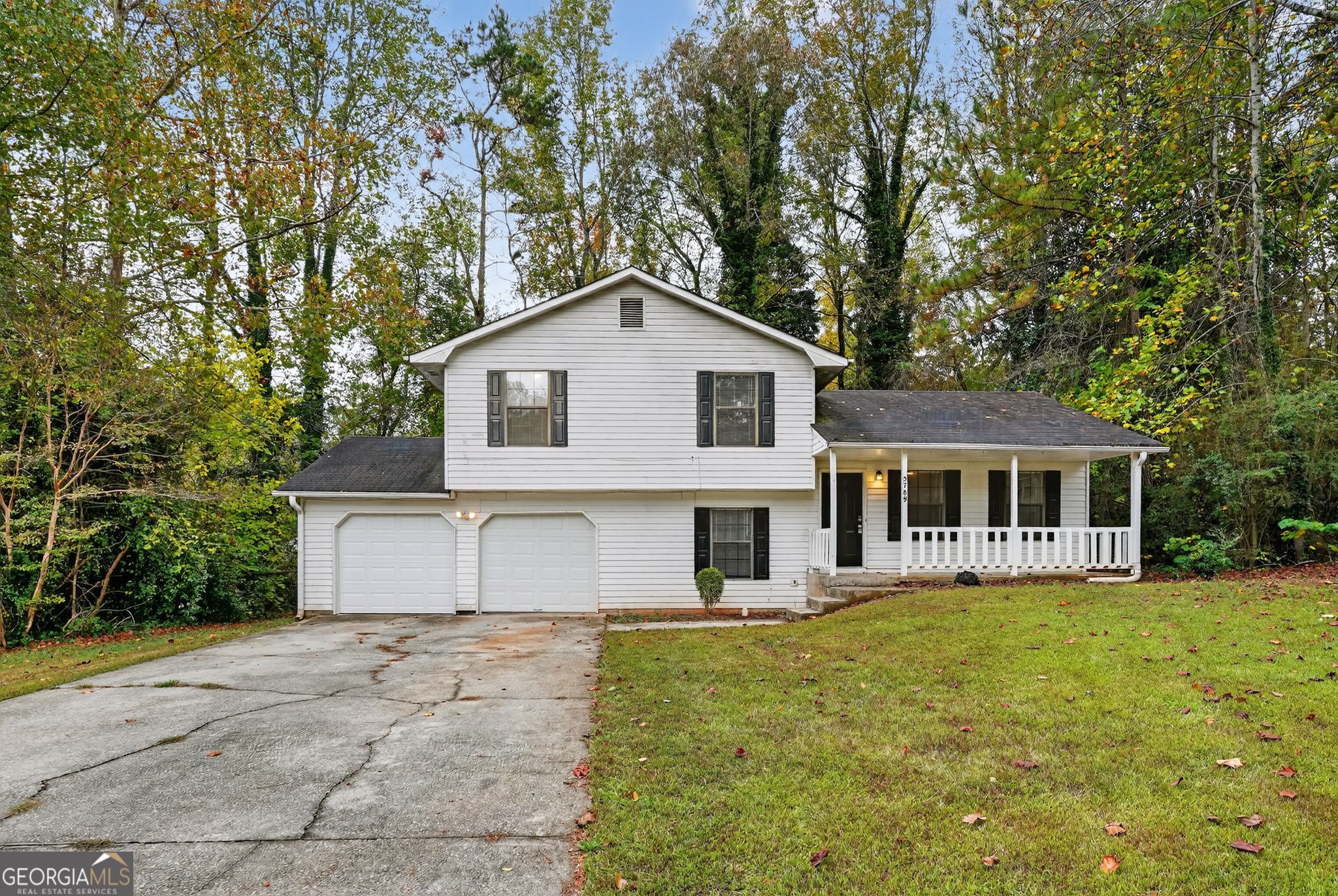 a front view of a house with a yard and trees
