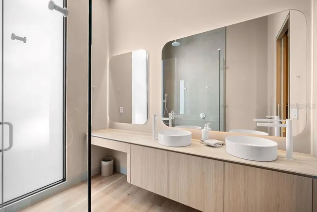 a bathroom with double vanity sinks and a mirror